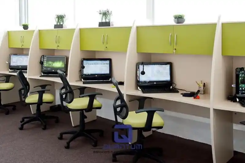 Grupo de personas trabajando en una estación de trabajo colaborativa, con monitores y espacio compartido.