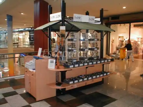Kiosco de accesorios para celular con vitrinas iluminadas y variedad de productos tecnológicos, ubicado en un centro comercial en CDMX.