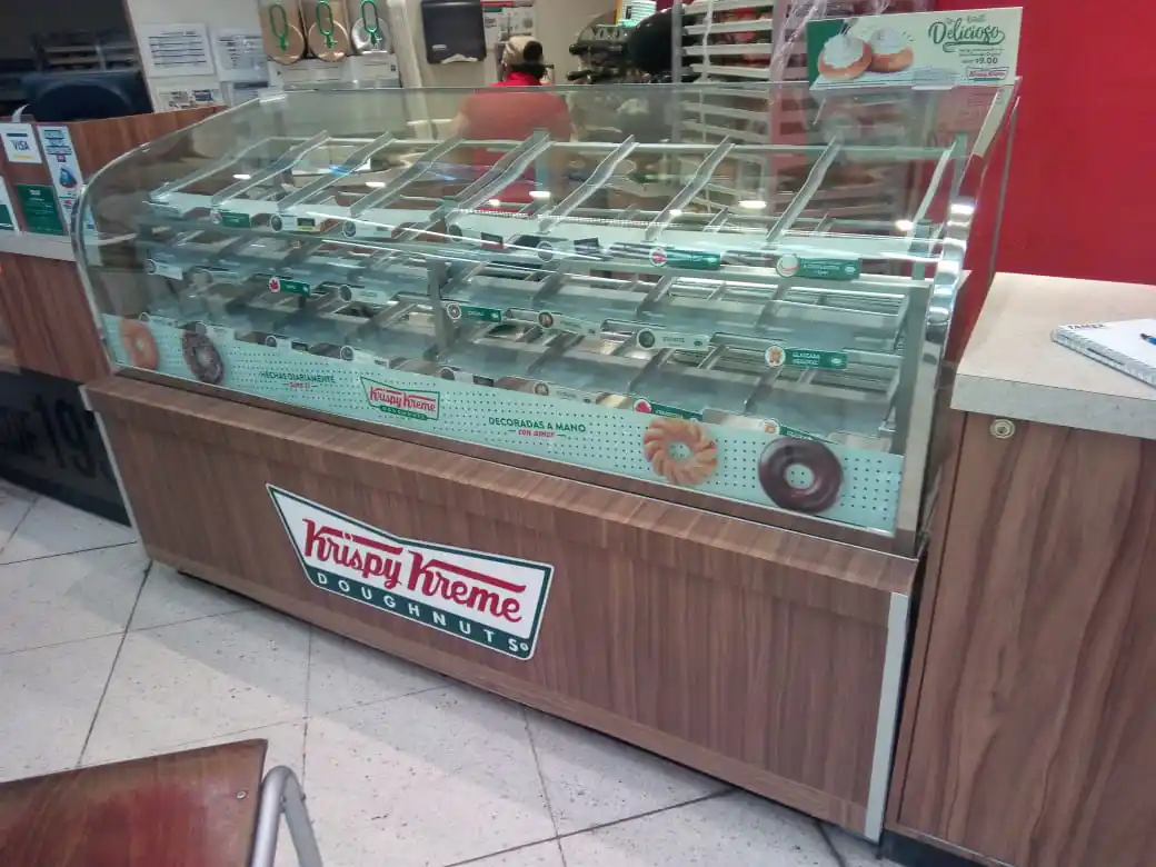 Kiosco de comida vibrante con área de preparación y atención, sirviendo bebidas en una plaza de comida en Guadalajara.