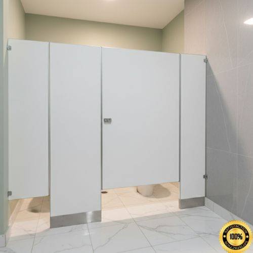 Instalación de mamparas esmaltadas blancas que incluye un cubículo accesible tipo ADA más ancho, con zoclos de acero inoxidable, en un baño público moderno.