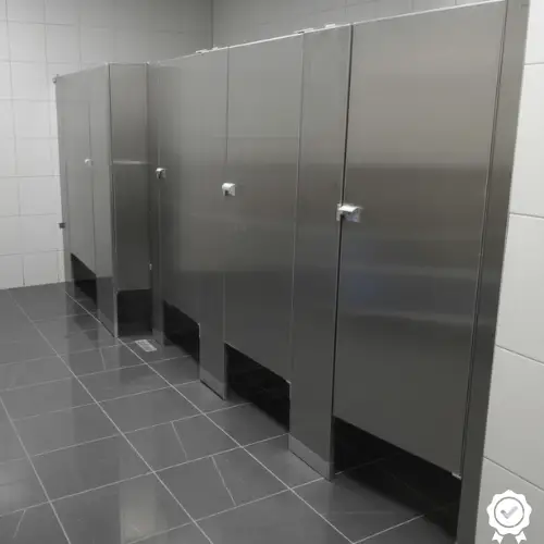Mamparas de Acero Inoxidable para Baños de Uso Rudo y Corporativos en Querétaro. Cuatro cabinas de mamparas de acero inoxidable en un baño comercial. Solución ideal para la máxima durabilidad y resistencia a la corrosión y el vandalismo.