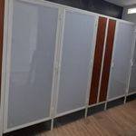 Línea de mamparas con marco de aluminio blanco y paneles de color claro combinados con detalles en café, instaladas en una oficina de Lomas del Valle, Guadalajara.