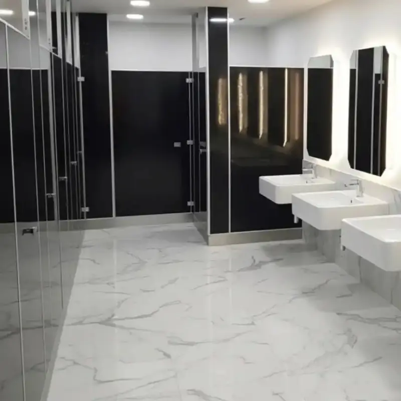 Mamparas para sanitarios públicos con diseño negro y canceles en acero inoxidable instaladas en campus universitario en Hermosillo, Sonora, diseñadas para alto tráfico y bajo mantenimiento en 24 edificios de proyectos educativos