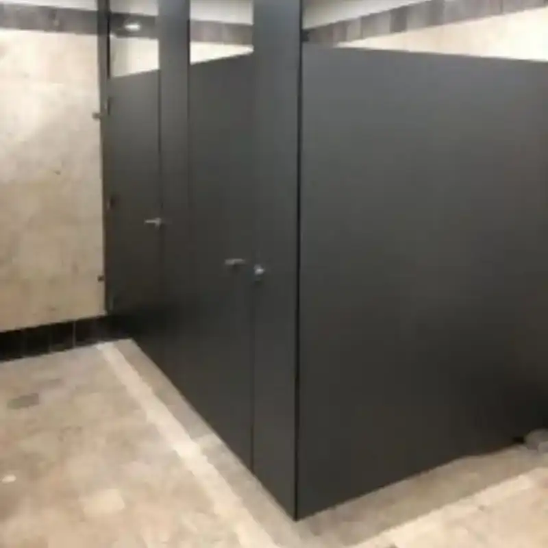 Mamparas sanitarias de sólido fenólico en color negro mate con herrajes de acero inoxidable, instaladas en sanitarios de colegio privado en Miguel Hidalgo, Ciudad de México