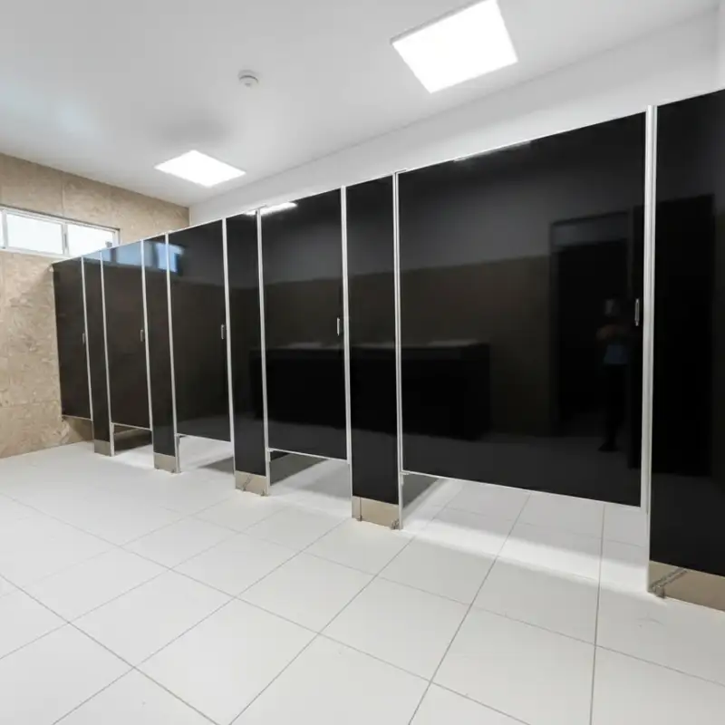 Mamparas sanitarias de sólido fenólico en color negro con herrajes de acero inoxidable instaladas en los baños de alto tráfico de una plaza comercial en Ciudad Satélite, Naucalpan de Juárez, por Mamparas Funcionales
