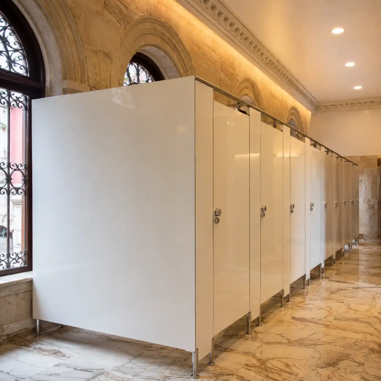 Instalación de mamparas para baños públicos en sólido fenólico blanco con herrajes de acero inoxidable en centro comercial de Cadereyta de Montes, Querétaro.